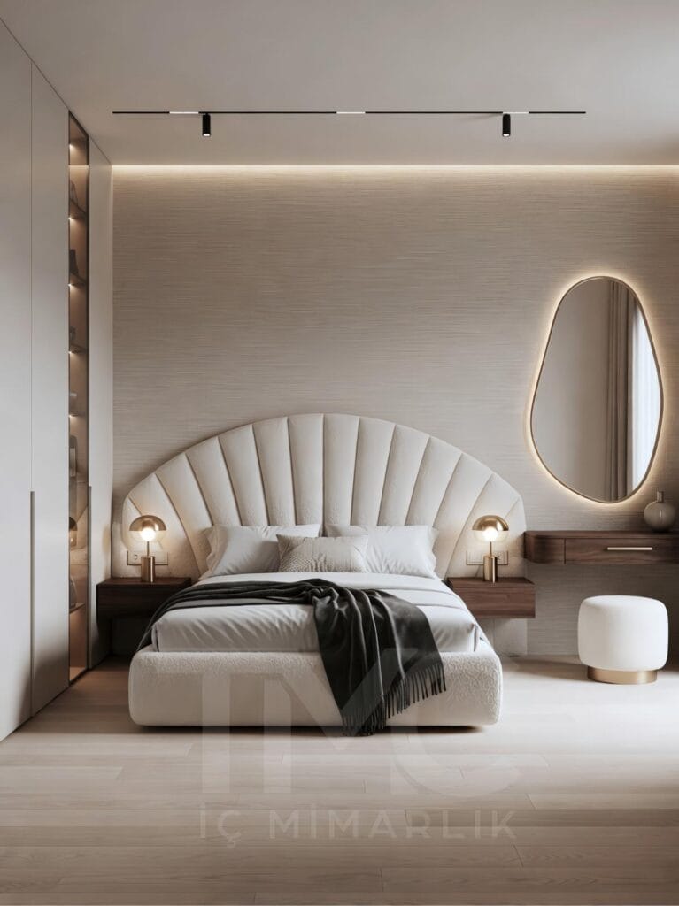 Modern yatak odası tasarımı, ölçüye özel panel duvar uygulaması, soft krem ve bej tonlarında minimal dekorasyon, gizli LED aydınlatmalı duvar paneli, entegre makyaj masası ve yuvarlak aydınlatmalı ayna, modern iç mimari yatak odası çözümü.