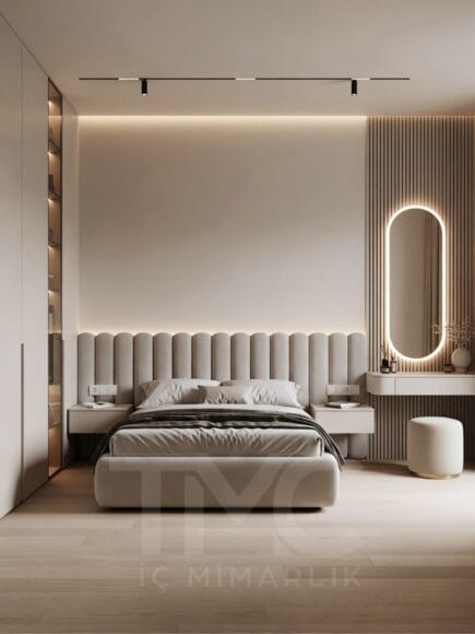 Modern yatak odası tasarımı, ölçüye özel panel duvar uygulaması, soft krem ve bej tonlarında minimal dekorasyon, gizli LED aydınlatmalı duvar paneli, entegre makyaj masası ve yuvarlak aydınlatmalı ayna, modern iç mimari yatak odası çözümü.