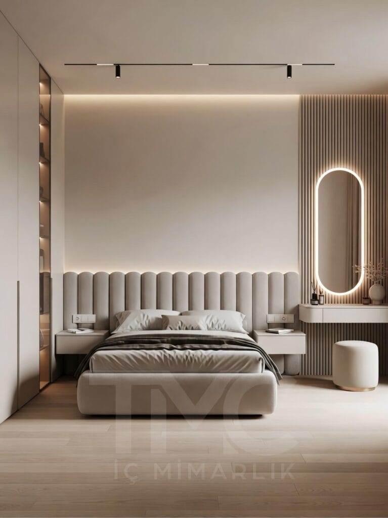 Modern yatak odası tasarımı, ölçüye özel panel duvar uygulaması, soft krem ve bej tonlarında minimal dekorasyon, gizli LED aydınlatmalı duvar paneli, entegre makyaj masası ve yuvarlak aydınlatmalı ayna, modern iç mimari yatak odası çözümü.
