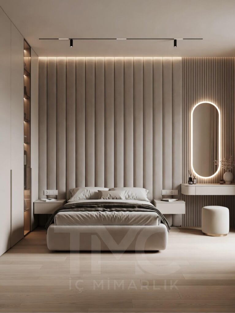 Modern yatak odası tasarımı, ölçüye özel panel duvar uygulaması, soft krem ve bej tonlarında minimal dekorasyon, gizli LED aydınlatmalı duvar paneli, entegre makyaj masası ve yuvarlak aydınlatmalı ayna, modern iç mimari yatak odası çözümü.