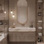 Toskana Vadisi Evleri’nde Selin & Emre için tasarlanan modern banyo; vizon tonlu dolap, mermer tezgah, arkadan LED aydınlatmalı oval ayna ve nervür panel detaylarıyla lüks ve sade iç mimari tasarım.