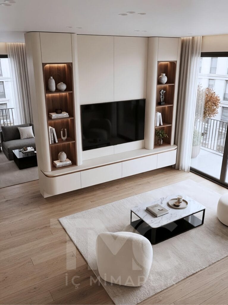 Toskana Villaları için tasarlanan modern TV ünitesi projesi; krem tonlu özel üretim panel uygulaması, doğal ahşap niş detayları, sıcak LED aydınlatmalar, gizli depolama alanları ve minimal salon dekorasyonu ile lüks ve modern iç mimari tasarım örneği.