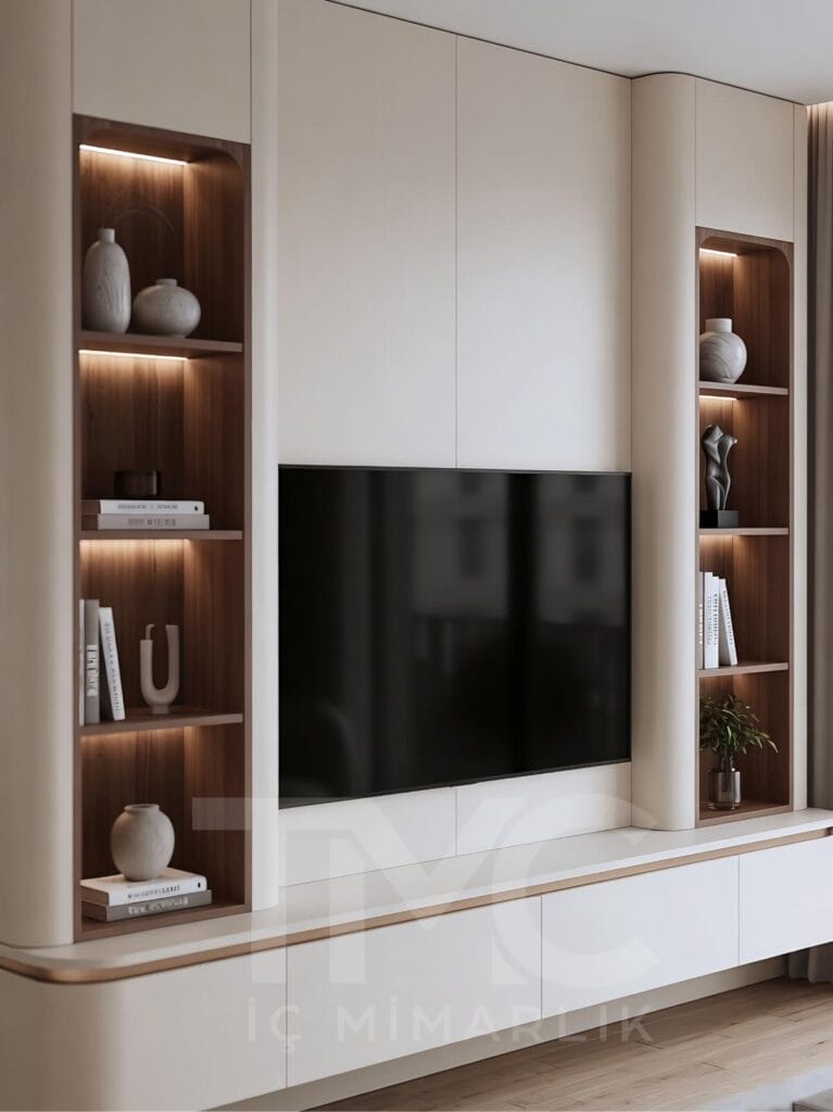 Toskana Villaları için tasarlanan modern TV ünitesi projesi; krem tonlu özel üretim panel uygulaması, doğal ahşap niş detayları, sıcak LED aydınlatmalar, gizli depolama alanları ve minimal salon dekorasyonu ile lüks ve modern iç mimari tasarım örneği.