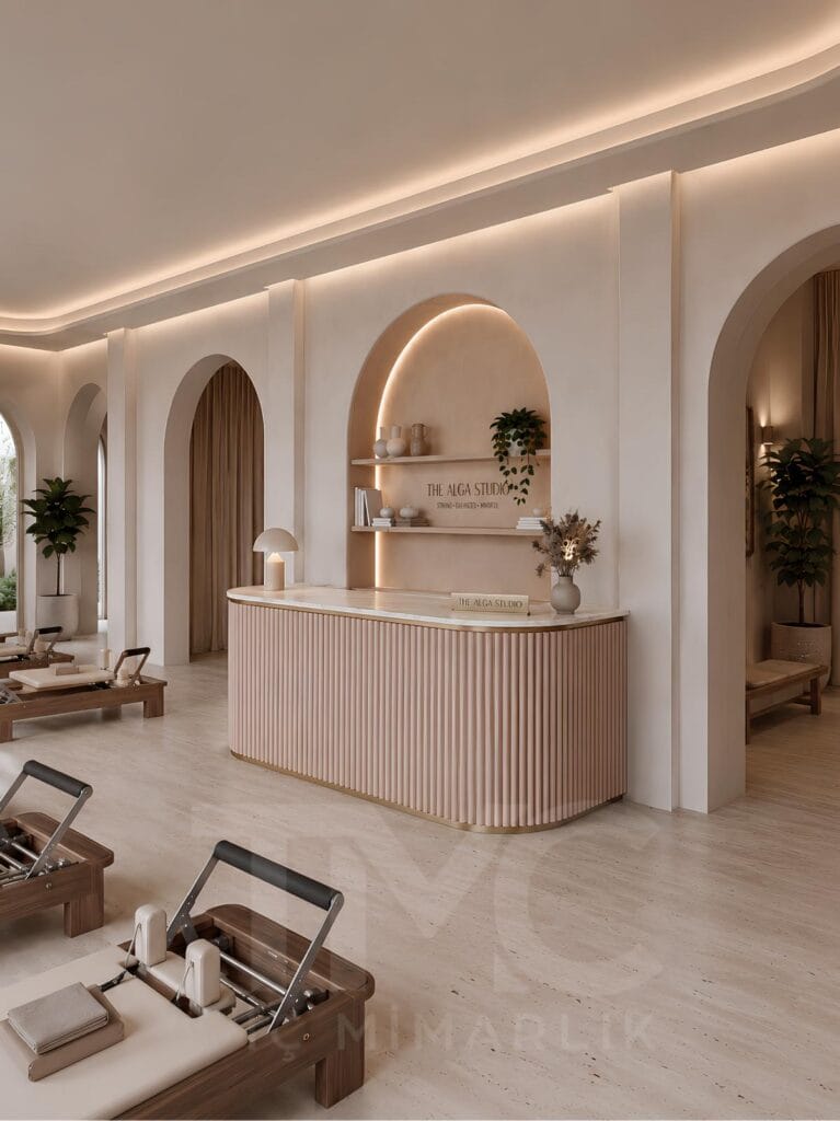 Modern pilates stüdyosu iç mimari tasarımı, doğal tonlarda butik pilates salonu dekorasyonu, kemerli mimari detaylı wellness studio tasarımı, sıcak LED aydınlatmalı pilates alanı, modern karşılama bankosu ve bekleme alanı tasarımı, açık bej renk paletli premium spor stüdyosu iç mekanı, TMC Mimarlık özel pilates stüdyosu projesi.