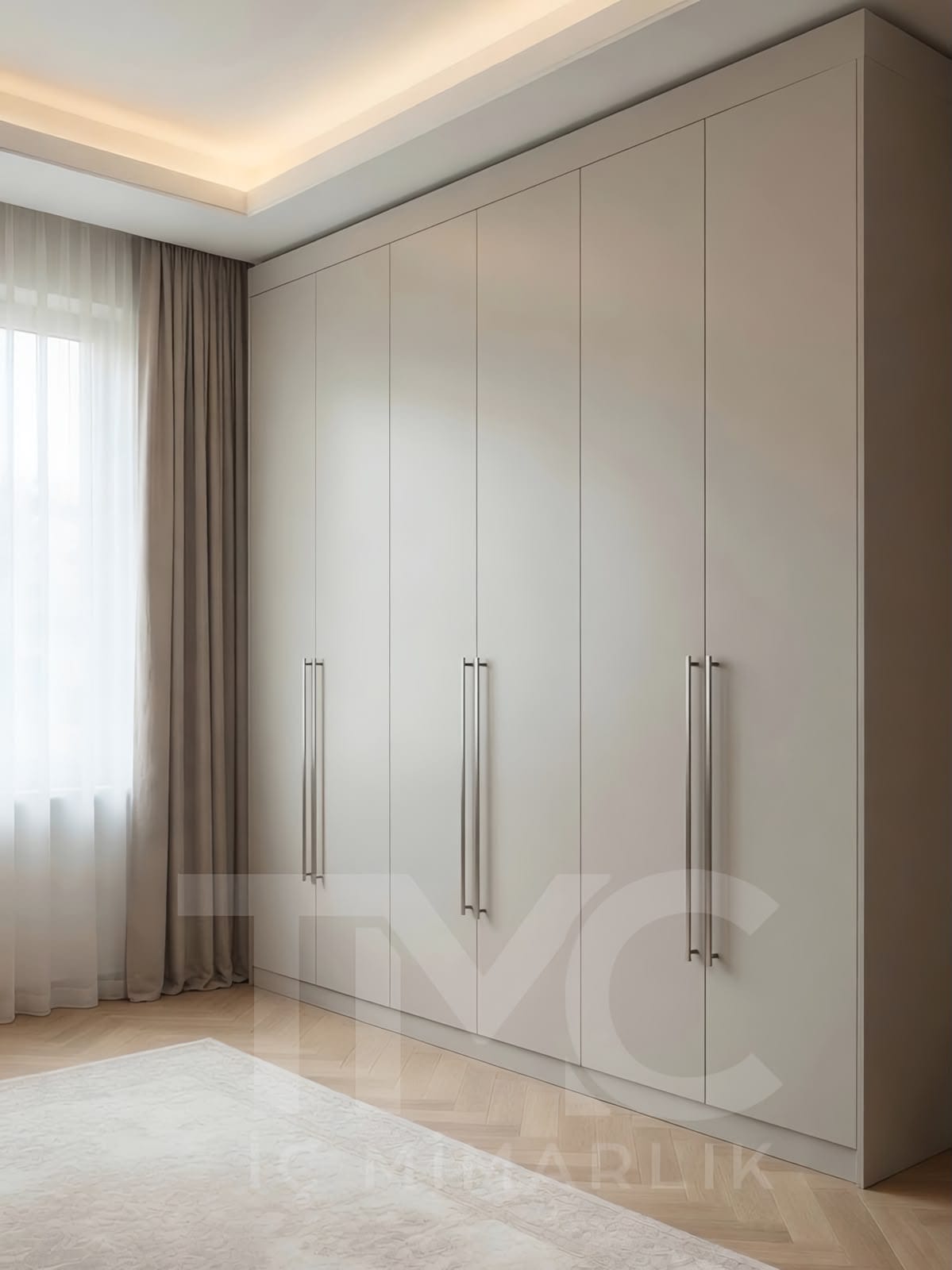 Tavana kadar uzanan modern bej gardırop tasarımı, özel ölçü üretilmiş lake kapaklı yatak odası dolabı. Minimal çizgiler, uzun metal kulplar ve şık detaylarla tasarlanan Üsküdar TMC İç Mimarlık projesi.